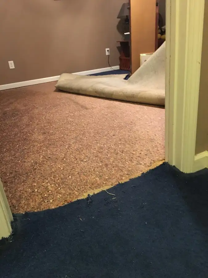 Carpet pad removal revealing water damage during Water Mitigation Services in Tuba City